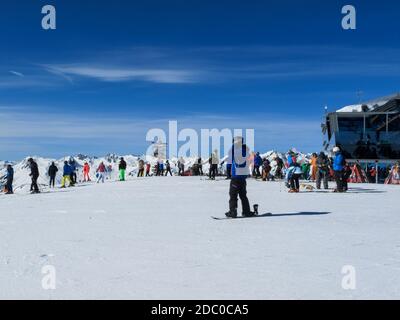 Snowboarder e sciatori in cima al Pardatschgrat, località sciistica di Ischgl-Samnaun, Austria Foto Stock