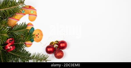 Sfondo di Natale con biscotti di pan di zenzero e ramo di pino su bianco. Foto Stock