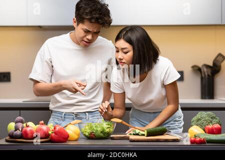 Coppia asiatica imparare a cucinare insieme in cucina moderna Foto Stock
