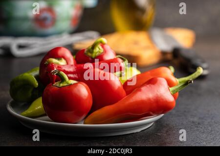 Vari tipi di peperoni vegetali su tavola nera. Foto Stock
