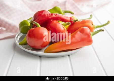 Vari tipi di peperoni vegetali su tavola bianca. Foto Stock