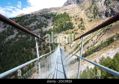 Ponte sospeso Charles Kuonen nelle Alpi svizzere. Con 494 metri, è il ponte sospeso più lungo del mondo nel paesaggio estivo in cielo blu Foto Stock