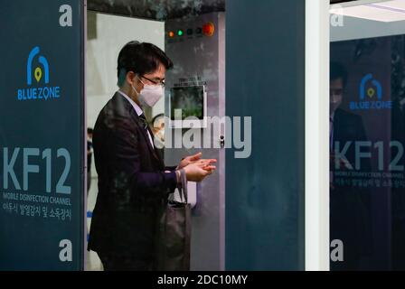 Goyang, Corea del Sud. 18 Nov 2020. Un visitatore passa attraverso un canale di disinfezione mobile prima di entrare nella sala espositiva del Korea International Exhibition Center a Goyang, nella provincia di Gyeonggi, Corea del Sud, 18 novembre 2020. La Corea del Sud ha deciso martedì di innalzare la sua regola di distanziamento sociale a cinque livelli di una tacca nell’area metropolitana di Seoul, in mezzo alla rinascita della COVID-19 nella capitale e nei suoi dintorni. Credit: Wang Jingqiang/Xinhua/Alamy Live News Foto Stock