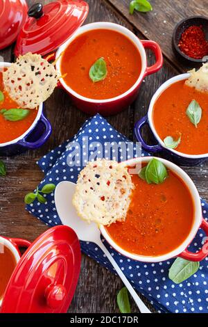 Zuppa di pomodoro fatta in casa in piccole pentole con cracker di parmigiano Foto Stock