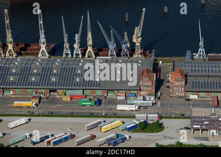 GERMANIA Amburgo, pannello fotovoltaico della società Amburgo energia sul tetto del deposito portuale edificio n. 50-52, parcheggio camion presso la Wharf store house / DEUTSCHLAND Hamburgs groesste Photovoltaik Anlage auf dem Kaischuppen 50-52 im Hamburger Hafen, Betreiber ist der staedtische Energieversorger Hamburg Energie, Die 30.000 Quadratmetro Dachflaeche werden von Stiftung Hamburg Maritim gepachtet Foto Stock