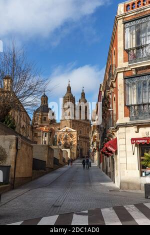 Salamanca strada con alcune persone a piedi e vista di la Clerecia sullo sfondo, Castille e Leon, Spagna Foto Stock