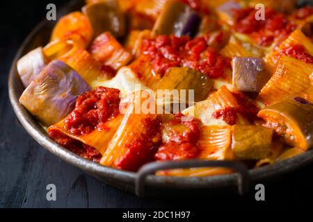 primo piano di rustica pasta rigatoni al formaggio italiano con melanzane e salsa di pomodoro Foto Stock