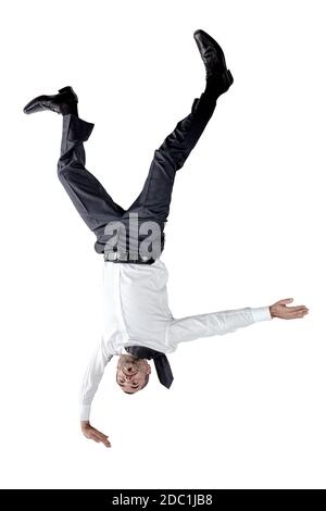 Uomo d'affari capovolto equilibrio da una parte. Isolato su bianco. Foto Stock
