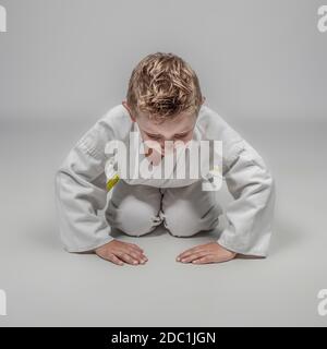 bambino che pratica arti marziali in posizione rei. studio shot Foto Stock