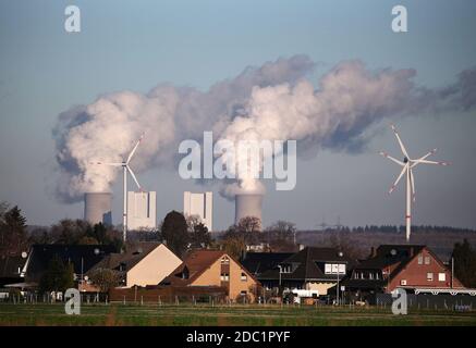 Grevenbroich, Germania. 18 Nov 2020. Dietro una proprietà immobiliare nei pressi di Grevenbroich, le turbine eoliche stanno girando di fronte alla centrale elettrica alimentata a lignite Neurath II della società di fornitura di energia RWE. Credit: Liver Berg/dpa/Alamy Live News Foto Stock