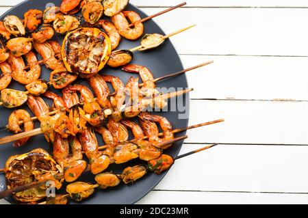 Deliziosi gamberi arrostiti e cozze su spiedini di legno Foto Stock