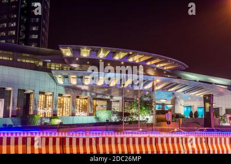 Vista notturna con torre del Regno alla luce del neon con centro commerciale nel quartiere Olaya di Riyadh, Arabia Saudita Foto Stock