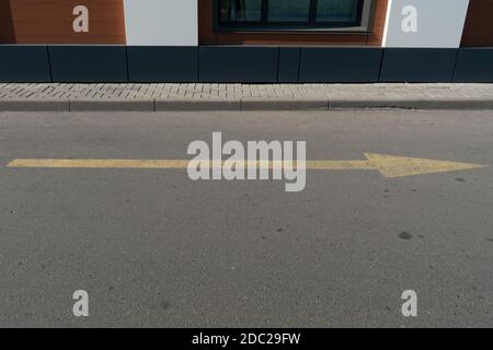 Freccia gialla sull'asfalto che indica traffico. Foto Stock