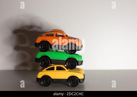 Tre coloratissime auto giocattolo realizzate in plastica riciclabile atossica su sfondo isolato, zero rifiuti, eco concept Foto Stock