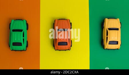 Tre coloratissime auto giocattolo realizzate in plastica riciclabile, consentono di risparmiare energia, non tossiche, riducono la produzione di gas serra Foto Stock