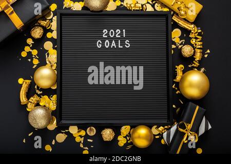 2021 testo degli obiettivi su Letter Board nero con oro Natale arredamento festivo, palle confetti. Nuovo anno 2021 obiettivi, risoluzione, lista di controllo con motivazione Foto Stock