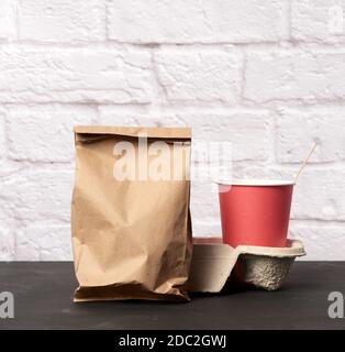 i vasetti monouso in carta rossa si trovano nel vassoio, sfondo bianco, contenitori per la rimozione Foto Stock