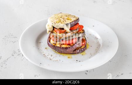 Melanzane a fette con pomodori ciliegini e mozzarella fusa Foto Stock