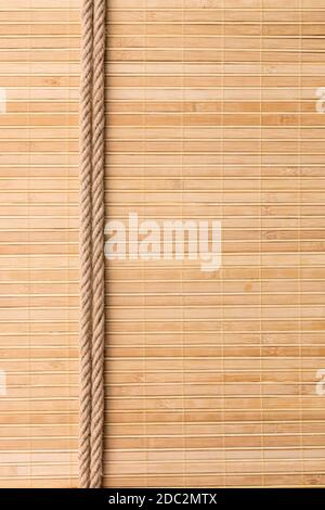 Telaio di due corde lisce giacenti su un tappeto di bambù, con spazio per il testo Foto Stock