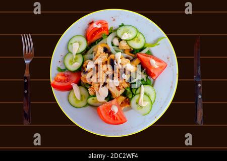 Un piatto di pollo e insalata di funghi su un marrone tabella Foto Stock