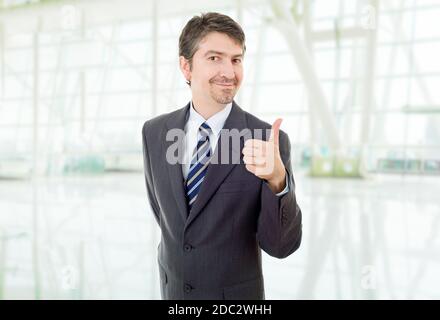 Giovane uomo d affari andando pollice in alto, presso l'ufficio Foto Stock