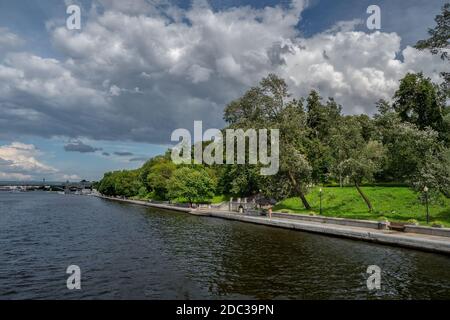 L'argine del fiume Mosca. Un argine verde ombreggiato lungo un ampio fiume. Foto Stock