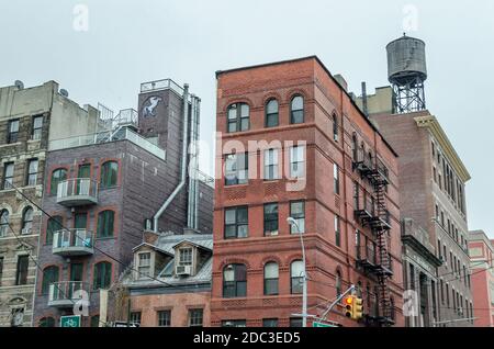 Tipici blocchi di appartamenti di Manhattan con scale di fuga dal fuoco e Water Tower sul tetto. Soho quartiere. Foto Stock