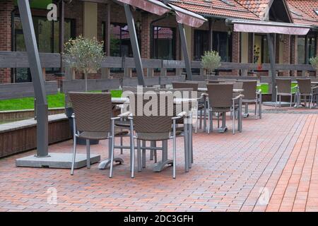 Terrazza con tavoli e sedie all'aperto in rattan. Sedie e tavoli nel ristorante all'aperto della città europea. Patio nel giorno d'estate. Resort. Foto Stock