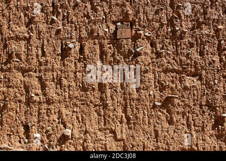 Background e texture - marrone parete di argilla con urti e crepe Foto Stock