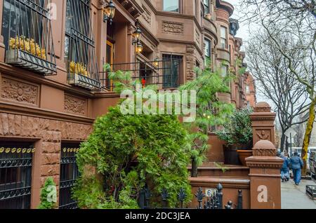 Harlem tradizionale Neigborhood. Case di Brownstone di stile simile in una fila e persone che camminano sul marciapiede. New York City, Stati Uniti Foto Stock
