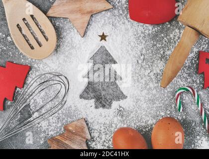 Farina sotto forma di un tree.Baking di natale ingredienti e cottura Attrezzatura per biscotti natalizi su sfondo grigio Foto Stock