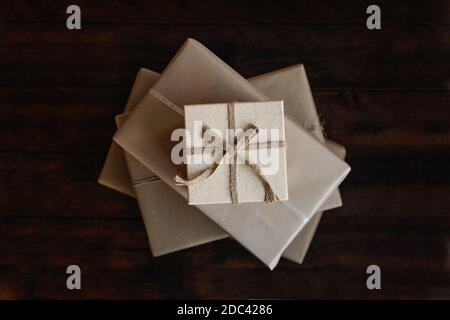 Vista dall'alto pila di molte confezioni regalo di Natale avvolte in carta riciclata kraft. Confezioni regalo di Natale eco-compatibili, sostenibili, senza sprechi, colore naturale Foto Stock
