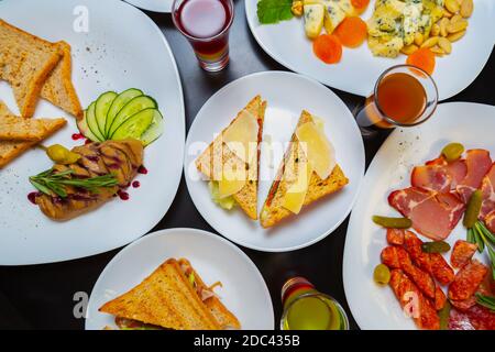 Snack sul tavolo in flay Lay.Delicious antipasti e spuntini servito per festa su piatti di ceramica bianca nel ristorante, girato direttamente Da sopra.Tasty Foto Stock