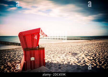 Sedia da spiaggia rossa vuota su una spiaggia vicino al Baltico Mare Foto Stock