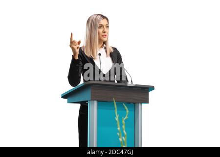 Donna professionale che dà un discorso su un piedistallo e gesturing con dito isolato su sfondo bianco Foto Stock