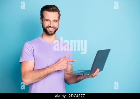 Ritratto fotografico di un allievo allegro che punta il dito verso il computer portatile sorridendo studio navigazione internet isolato sfondo blu vivido Foto Stock