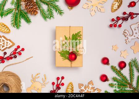 Sfondo bianco con baubles e presenta regalo in scatola artigianale con decoratoins. Natale senza sprechi, Capodanno, giorno del Ringraziamento. Disposizione flay, vista dall'alto Foto Stock