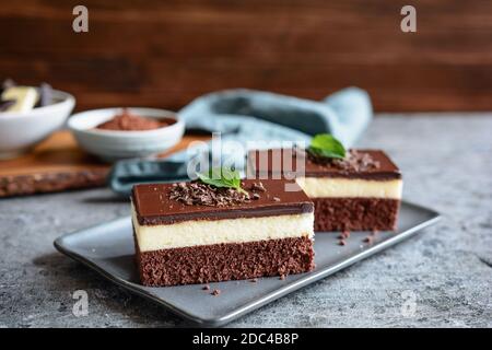 Barrette di cacao fatte in casa con cioccolato bianco e panna montata ripieno, condite con glassa di cioccolato fondente Foto Stock