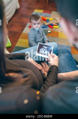 I genitori che osservano l'ecografia del loro nuovo bambino Foto Stock
