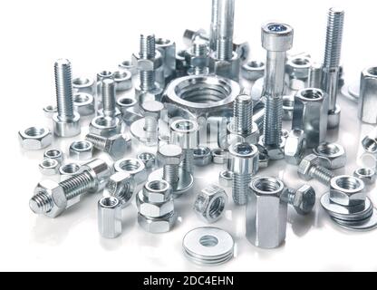 Chromeplated bulloni e dadi su sfondo bianco Foto Stock