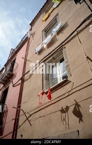 Costume da bagno appeso ad asciugare su un filo esterno alla finestra Di un edificio nell'antica città di Bosa Foto Stock