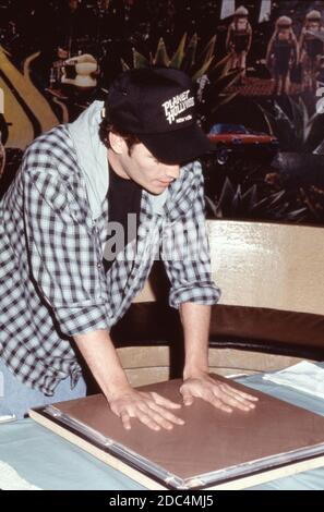 Beverly Hills 90210 attore Luke Perry al Planet Hollywood di New York, 4 febbraio 1993, mette le sue stampe a mano in una lastra di cemento. Foto Stock