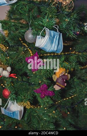 albero di natale concettuale decorato con maschere corona virus 2020 mondo pandemia Foto Stock