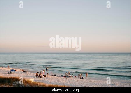 Persone su una Florida Panhandle, Gulf Coast, spiaggia nei pressi di Destin, in Florida, Stati Uniti d'America, al tramonto. Foto Stock