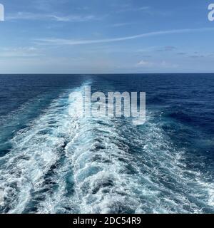 Nave da crociera sulla scia di una bella giornata di sole con nuvole bianche e mare azzurro dell'Oceano Atlantico. Foto Stock