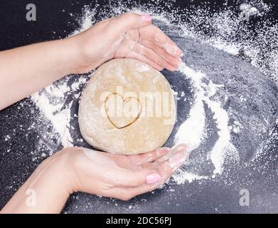 Cucinando i biscotti fatti in casa dall'impasto nella forma di a. cuore a bordo Foto Stock