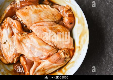 Ali di pollo crude con erbe e spezie per salsa marinata grigliate o cotte al forno Foto Stock