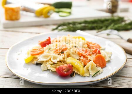 Piatto con gustosa pasta primavera sul tavolo, primo piano Foto Stock