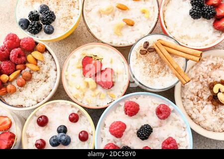 Ciotole di gustoso budino di riso con frutti di bosco su tavolo leggero Foto Stock