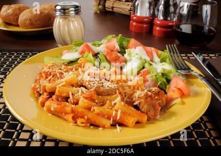 Salsiccia su tagliatelle rigatoni con salsa di pomodoro e formaggi Foto Stock